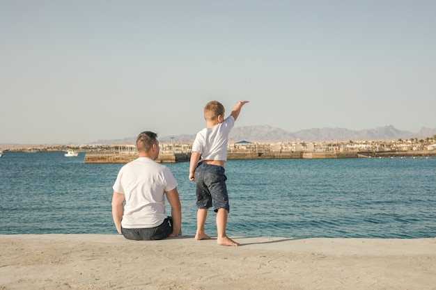 Padre e figlio trascorrono del tempo insieme in vacanza al mare