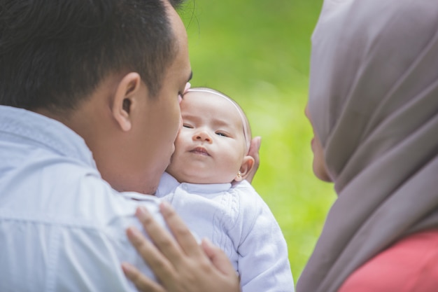 Padre e madre con il loro neonato nel parco.