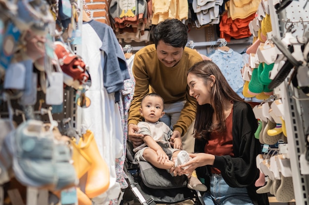 Padre e madre fanno la spesa al baby shop con il figlio nel passeggino