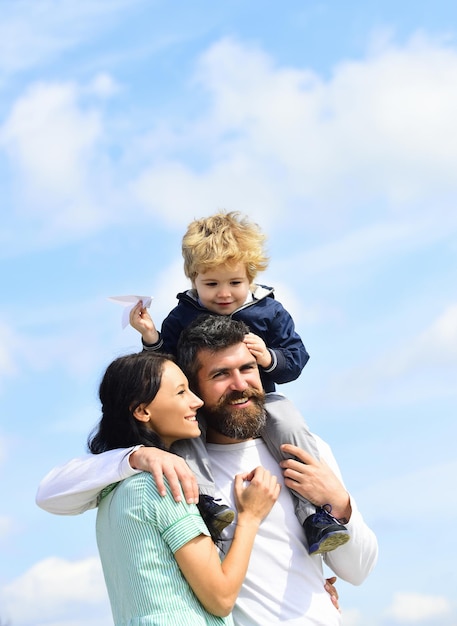 Padre e suo figlio bambino ragazzo che gioca all'aperto genitorialità padre felice che dà al figlio un giro sul cielo dentro