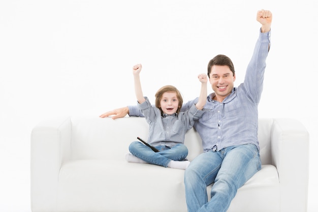 Padre e suo figlio giovane sorridente su un divano