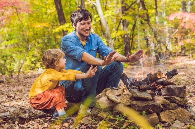 Padre felice che fa barbecue con suo figlio in una giornata autunnale