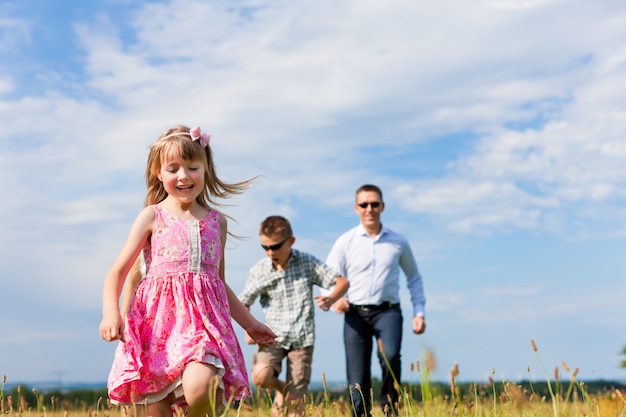 Padre felice che funziona con i suoi figli nella natura