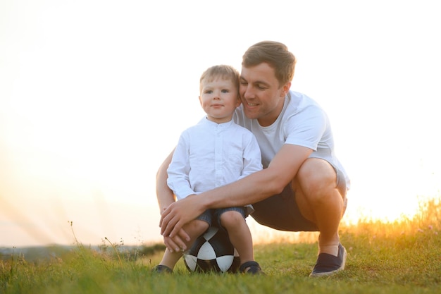 Padre felice che gioca con il figlio sullo sfondo del tramonto Il concetto di festa del papà