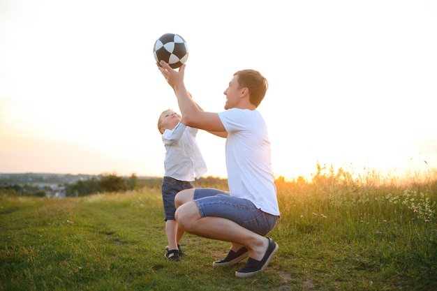 Padre felice che gioca con il figlio sullo sfondo del tramonto Il concetto di festa del papà