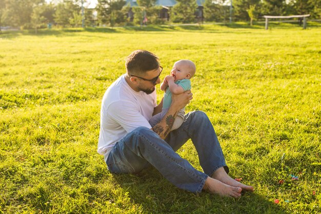 Padre felice che tiene il figlio del bambino, lanciando il bambino in aria. Concetto di famiglia felice, festa del papà e bambino.