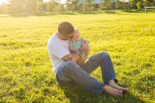 Padre felice che tiene il figlio del bambino, lanciando il bambino in aria. Concetto di famiglia felice, festa del papà e bambino.