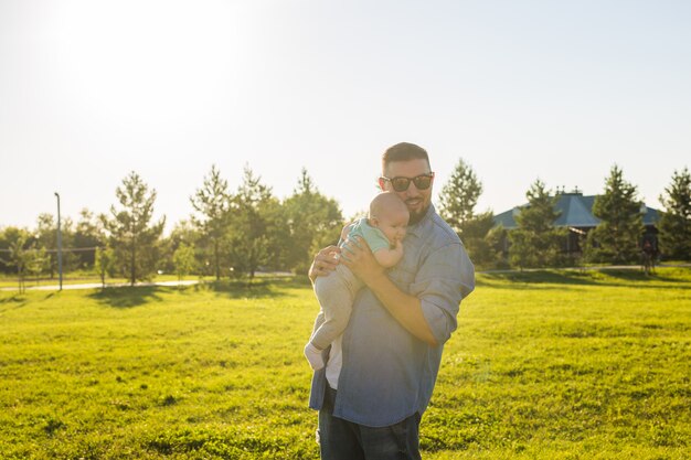 Padre felice che tiene in braccio il concetto di figlio bambino di felice festa del papà e bambino in famiglia