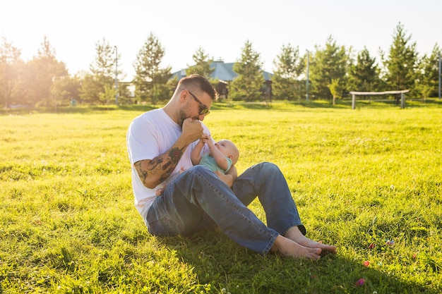 Padre felice che tiene in braccio il figlio del bambino sul concetto di natura di felice festa del papà e bambino in famiglia