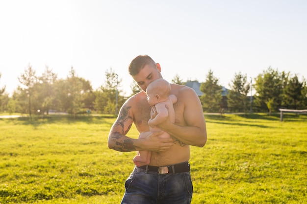 Padre felice che tiene in braccio il figlio del bambino sul concetto di natura di felice festa del papà e bambino in famiglia