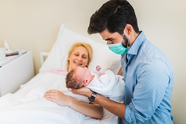 Padre felice che tiene in braccio il suo neonato.