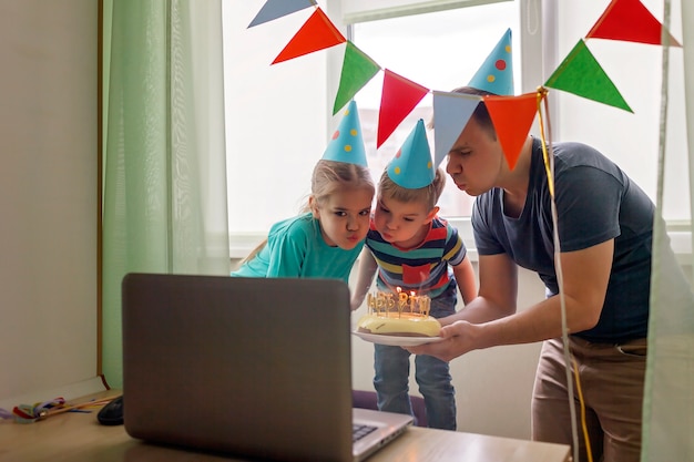 Padre felice con due fratelli festeggia il compleanno via internet in quarantena