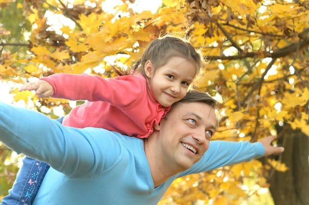 Padre felice con la figlia nel parco d'autunno