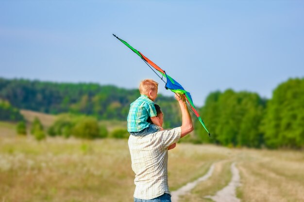 Padre felice e bambino che giocano nella natura in estate