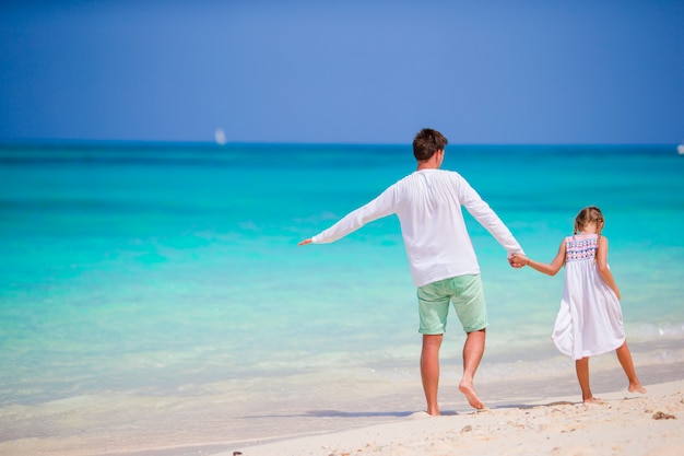 Padre felice e la sua adorabile figlioletta in spiaggia tropicale