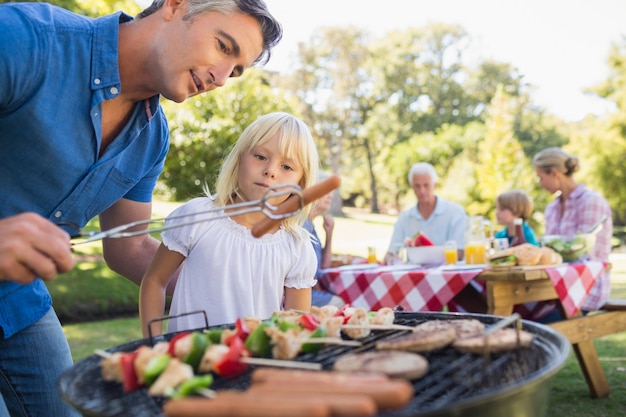 Padre felice facendo barbecue con sua figlia