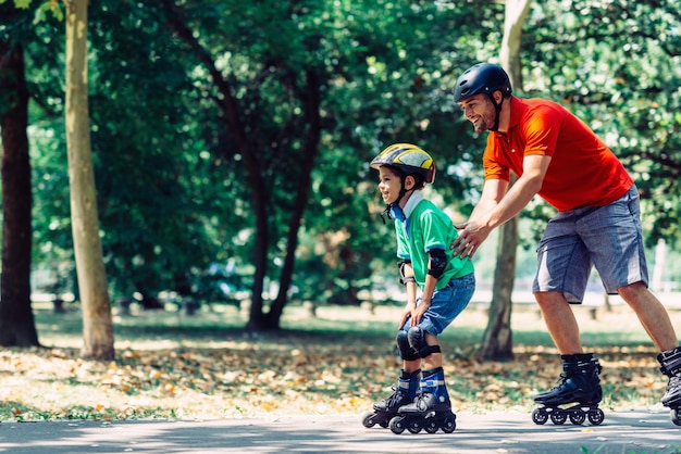 Padre figlio teching pattinaggio nel parco