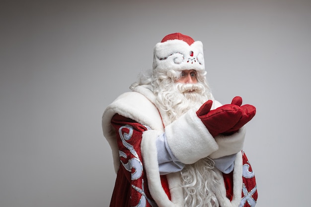 Padre gelo con la barba lunga attende il miracolo, immagine isolata sul muro grigio