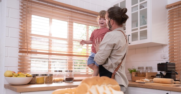 Padre in cucina della casa con un bambino piccolo Giocare e divertirsi cucinare la cena insieme