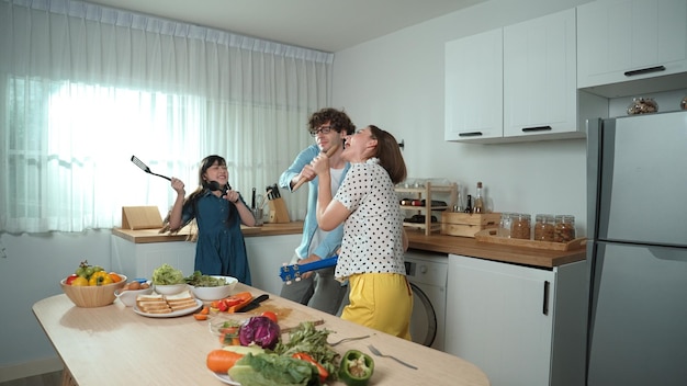 Padre, madre e figlia preparano la colazione mentre ballano insieme Pedagogia