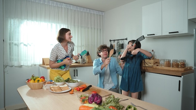 Padre, madre e figlia preparano la colazione mentre ballano insieme pedagogia