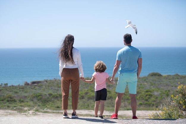 Padre madre e figlio sulla spiaggia estiva al tramonto sul concetto hawaii di famiglia amichevole