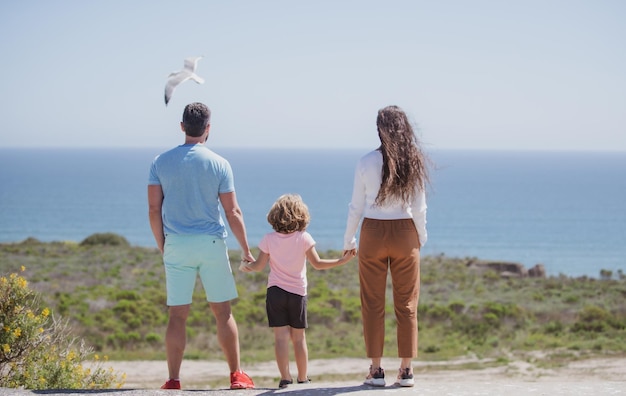 Padre madre e figlio sulla spiaggia estiva al tramonto sul concetto hawaii di famiglia amichevole