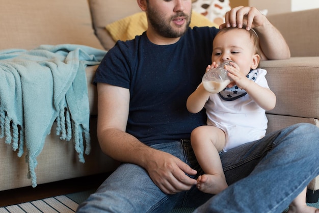 Padre moderno che gioca con il piccolo neonato