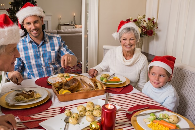 Padre nel cappello santa che serve arrosto di tacchino a Natale