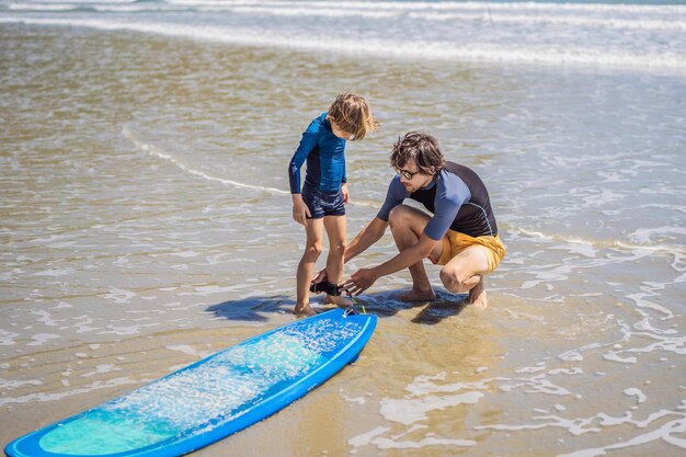 Padre o istruttore che insegna a suo figlio come fare surf in mare in vacanza o in vacanza e