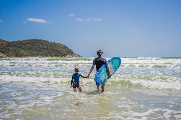 Padre o istruttore che insegna a suo figlio come fare surf in mare in vacanza o in vacanza e