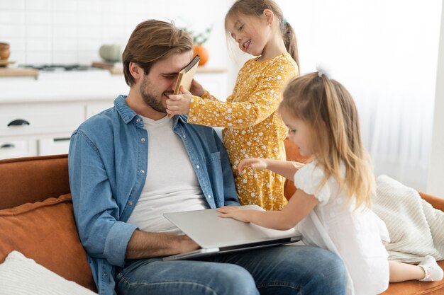 Padre stressato che lavora da casa con i bambini. Homeschooling, stare a casa, distanziamento sociale durante l'isolamento della quarantena del coronavirus, lavoro freelance