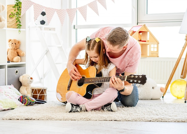 Padre suonare la chitarra con figlia carina