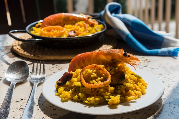 Paella cibo tipico spagnolo in fondo di granito