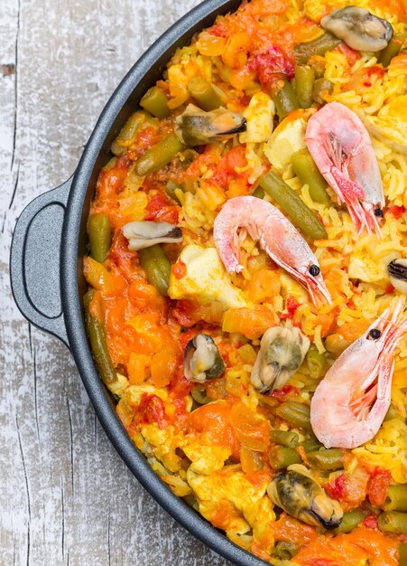 Paella con frutti di mare e verdure in padella