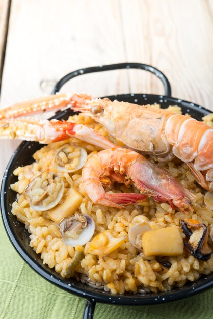 Paella di verdure con frutti di mare su un di legno