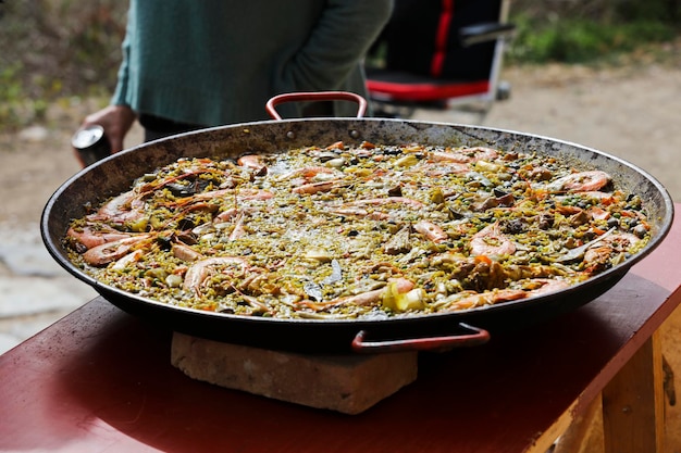 paella nel campo con fuoco e giornata di sole