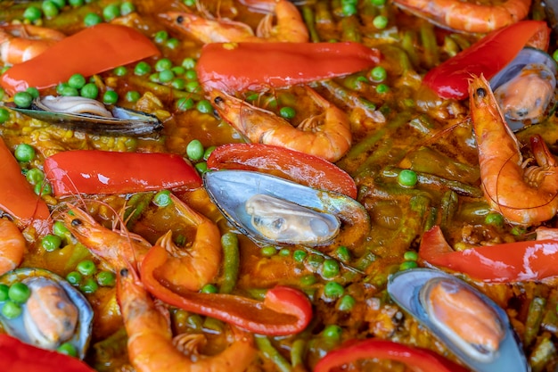 Paella spagnola di frutti di mare in padella con cozze gamberetti e verdure Primo piano di sfondo di paella di frutti di mare piatto di riso spagnolo tradizionale