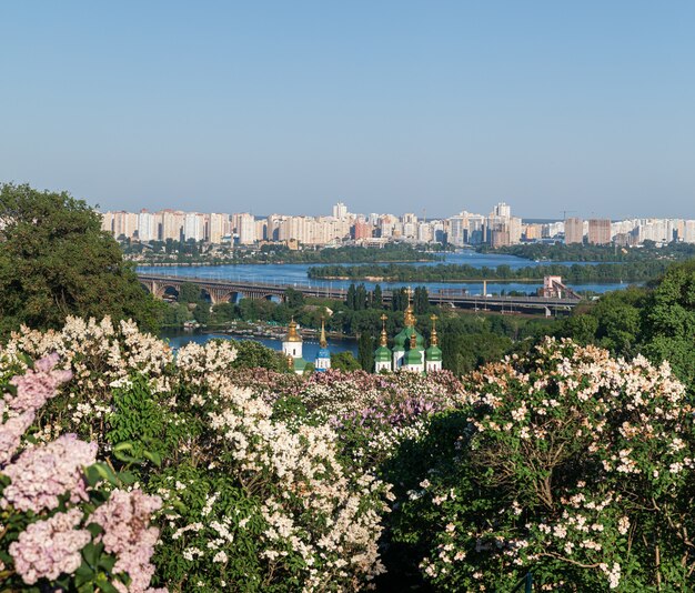Paesaggi di Kiev. Vista primaverile del monastero di Vydubychi e del fiume Dnipro con fiori lilla rosa e bianchi nel giardino botanico nella città di Kiev, Ucraina