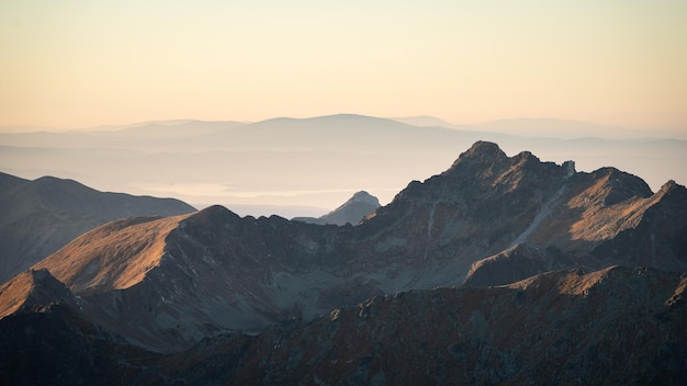 Paesaggio alpino con picchi di catene montuose che catturano l'ultima luce durante il tramonto Europa Slovacchia