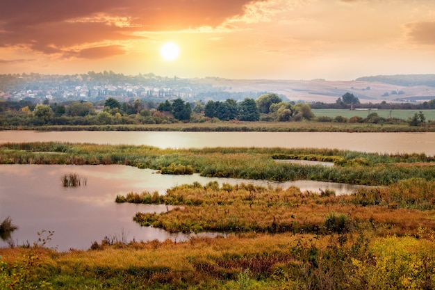 Paesaggio autunnale con il fiume al tramonto, veduta aerea da un'altezza.