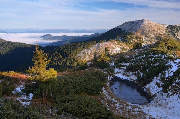 Paesaggio autunnale con la prima neve. Lago ghiacciato in montagna. La bellezza della natura. Carpazi, Ucraina, Europa