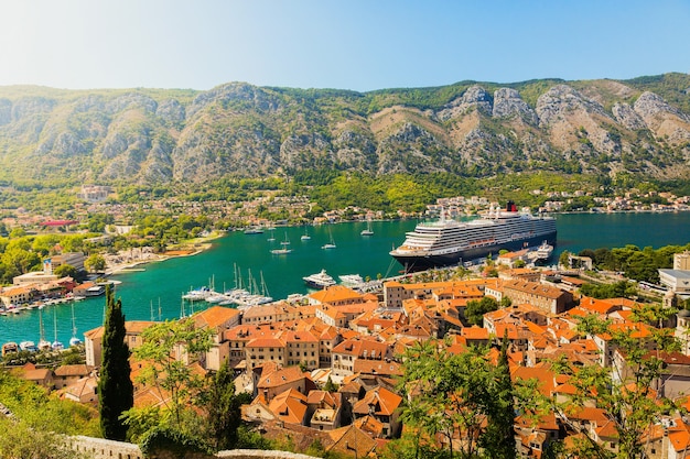 Paesaggio colorato con barche e yacht in marina bay, mare, montagne, cielo blu. Vista dall'alto della baia di Kotor, Montenegro