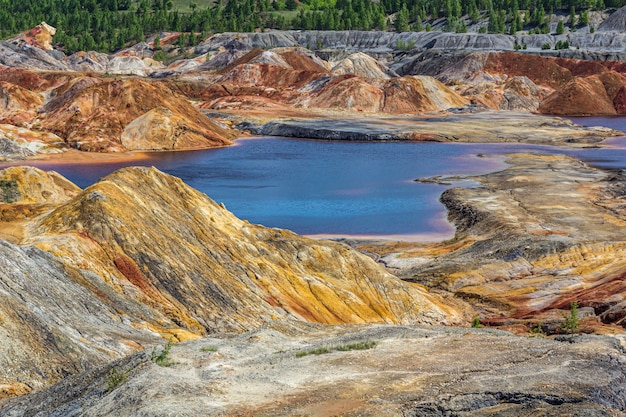 Paesaggio come la superficie di un pianeta Marte. Cave di argilla refrattaria degli Urali. Natura dei Monti Urali, Russia. Superficie della Terra nera marrone-rosso solidificata per screensaver per desktop, banner, copertina.