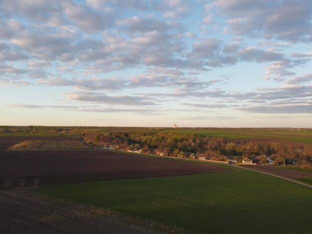 Paesaggio con appezzamenti in agricoltura Serata sul villaggio in primavera