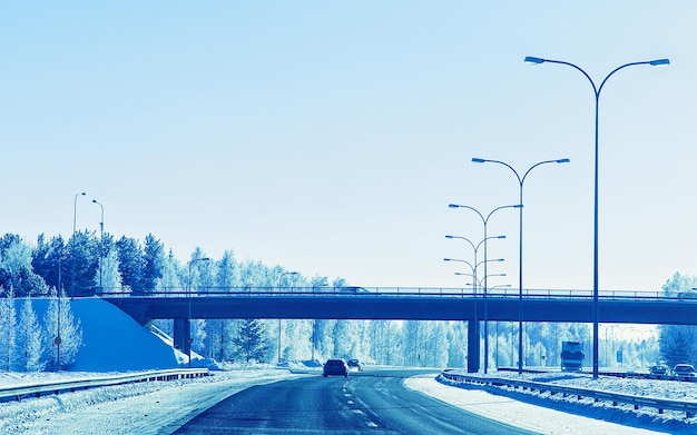 Paesaggio con auto e ponte sulla strada in caso di neve invernale Lapponia, Rovaniemi, Finlandia. Viaggio di vacanza in autostrada con la natura. Scenario con viaggio in auto in vacanza