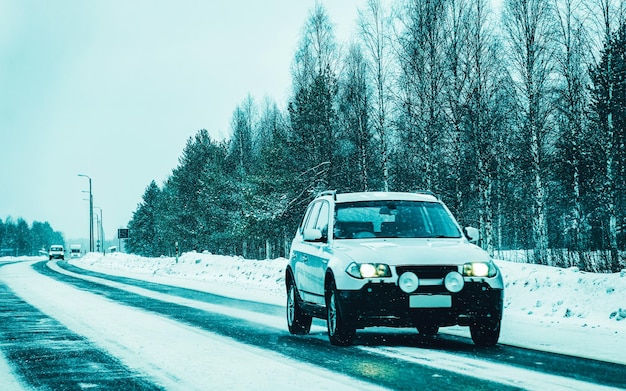 Paesaggio con auto su strada innevata in Finlandia. Viaggio di vacanza in autostrada con la natura. Scenario con viaggio invernale in viaggio per le vacanze per la ricreazione. Giro in moto in Europa. Trasporto su strada.