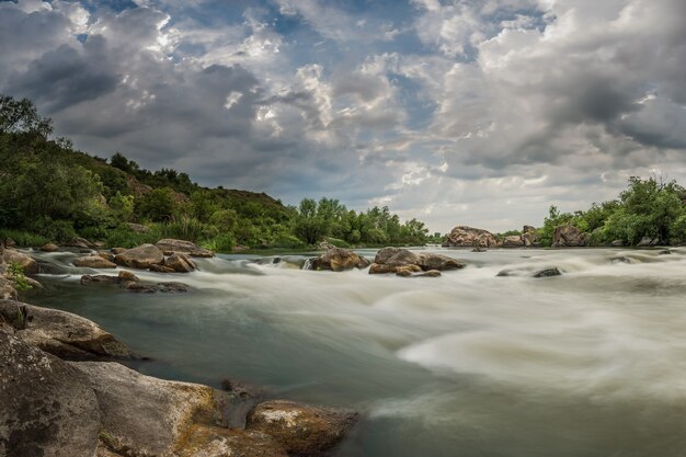 Paesaggio con maestoso cielo sopra il fiume di montagna