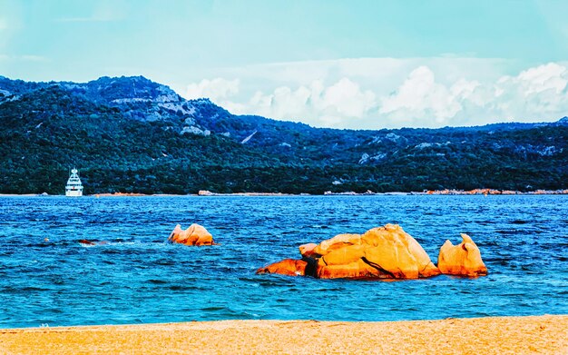 Paesaggio con mattinata romantica alla spiaggia di Capriccioli in Costa Smeralda del Mar Mediterraneo sull'isola di Sardegna in Italia. Cielo con nuvole. Porto Cervo e provincia di Olbia. Tecnica mista.