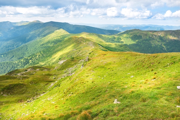 Paesaggio con montagne verdi e colline con cielo blu